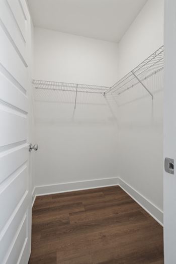 A white closet with a shelf and a door.